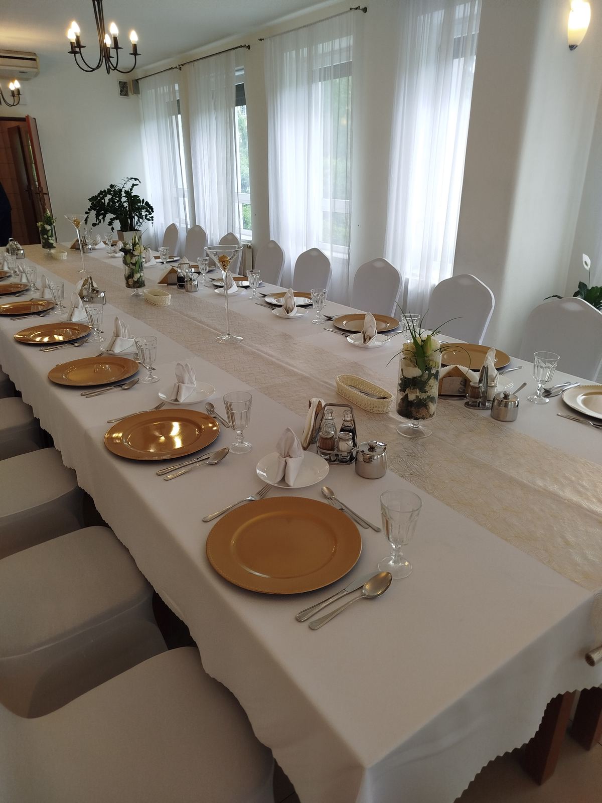 Złota zastawa na długim stole — sala na stypę w Grębałowie